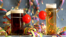 Kölschglas und Altglas mit Clownsnase und Luftschlangen