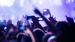 Konzertbesucher filmen in der Max-Schmeling-Halle in Berlin die Show