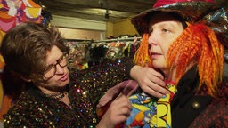 Eine kostümierte Frau wird beraten im Kostümshop