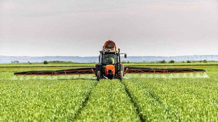 Ein Traktor verteilt Dünger auf einem Feld
