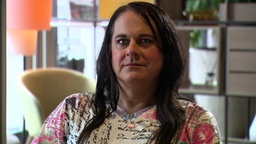Transfrau Marina aus Duisburg hat lange schwarze Haare und guckt direkt in die Kamera