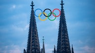 Bildmontage von den Spitzen des Kölner Doms zwischen denen die olympischen Ringe platziert sind