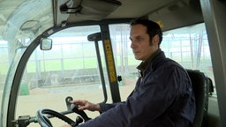 Landwirt Carl-Hendrik May fährt auf seinem Hof eine Maschine.