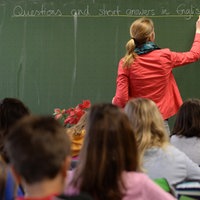 Lehrerin und Schüler im Klassenzimmer (Symbolbild)