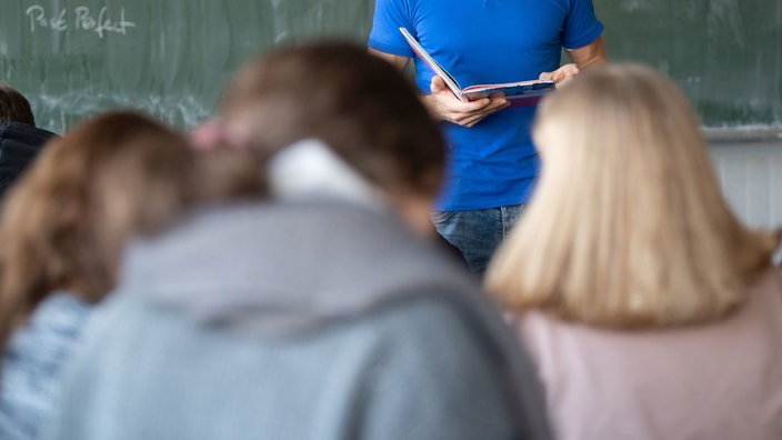 Ein Lehrer unterrichtet in einem Klassenzimmer einer Realschule