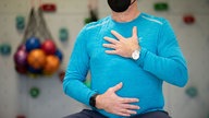 Atemtraining in einer Reha-Klinik: Ein Mann hält seine Hände auf Bauch und Brust.