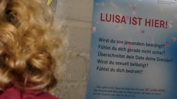 Frau neben Plaket "Luisa ist hier"