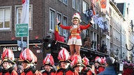 Eine Tanzmarie wird über den Köpfen getragen auf dem Düsseldorfer Marktplatz am 11.11.