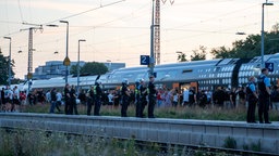 Polizisten bewachen die Fahrgäste eines Regionalzuges am Bahnhof Oelde