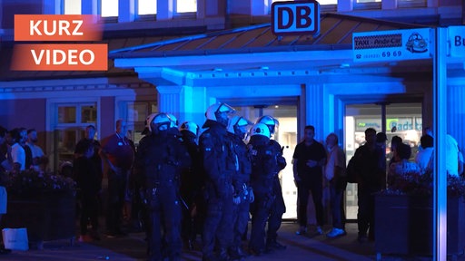 Ein Großaufgebot der Polizei bei Blaulicht vor einem Bahnhof