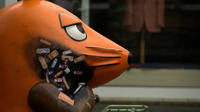 Angezündete Maus mit vielen bunten Pflastern
