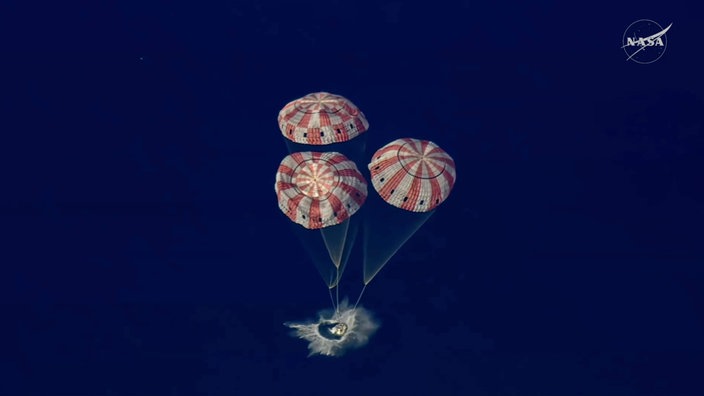 Die Raumkapsel "Artemis 2" während der Landung im Pazifischen Ozean mit drei Fallschirmen