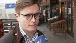 Ein Mann mit Brille im Interview