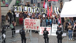 Gegendemonstranten halten Plakate hoch