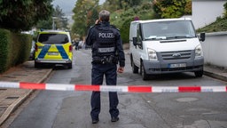 Ein Polizist steht in einem abgesperrten Bereich nach einem Messerangriff in Herdecke.