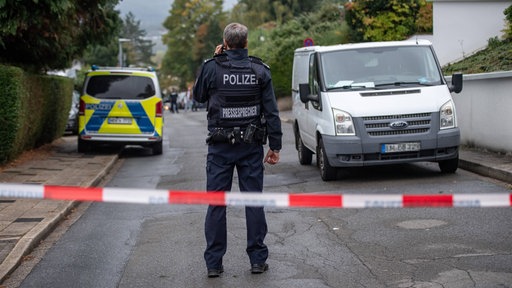 Ein Polizist steht in einem abgesperrten Bereich nach einem Messerangriff in Herdecke.