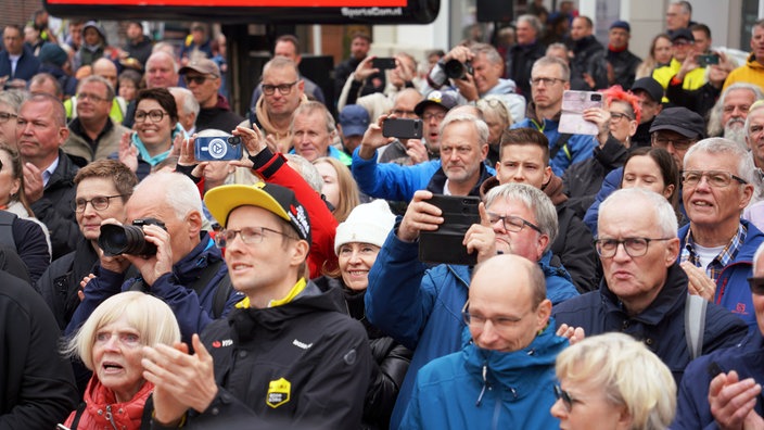 Die Fans zücken vor der Bühne in Oelde ihre Handys, um den Moment festzuhalten, wenn die Rad-Idole vorgestellt werden.