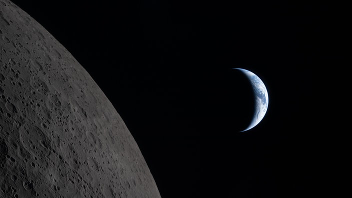 Die sichelförmige Erde verschwindet langsam hinter dem Mond
