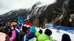 Zuschauer stehen am Rand einer Biathlon-Loipe
