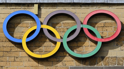An einer Mauer hängen die olympischen Ringe