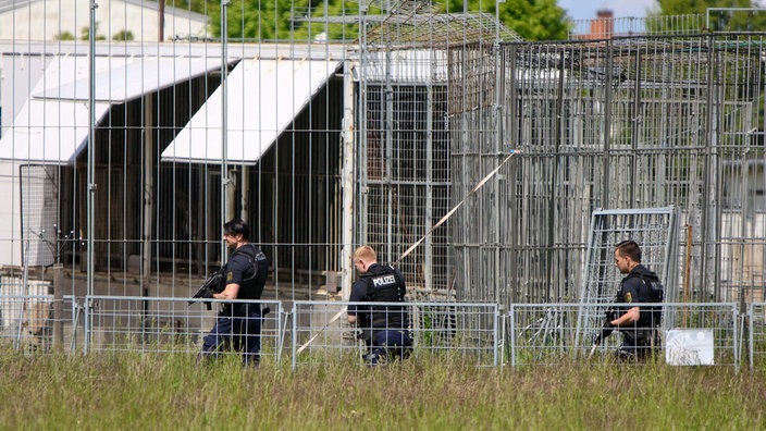 Schwer bewaffnete Polizisten sind an einer Käfig-Anlage für Raubkatzen im Einsatz