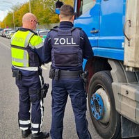 Ein Zoll- und ein Polizeibeamter vor einem LKW