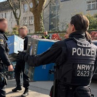 Polizeibeamte beladen während der Razzia einen LKW