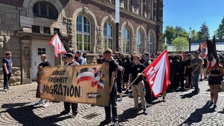 Rechtsextreme halten Banner und Fahnen auf Demo in Gelsenkirchen.