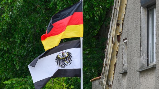 Gehisste schwarz-weiße Reichsbürgerflagge unter einer schwarz-rot-gelben Deutschlandflagge 
