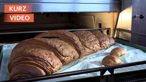 Ein riesiges Croissant kommt aus dem Backofen