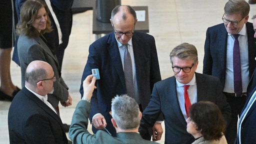 Bundeskanzler Friedrich Merz (CDU) gibt bei einer namentlichen Abstimmung über das Rentenpaket seine Stimmkarte im Bundestag ab