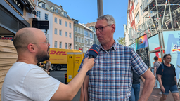 Ein Mann wird in der Bonner Innenstadt von einem WDR-Mitarbeiter zur Sperrung der Bonner Nord-Brücke interviewt.