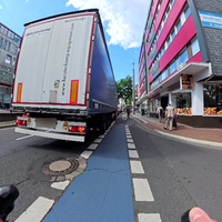Bild aus der Perspektive eines Radfahrers der über eine Kreuzung fährt die voll mit Autos und Lkw ist.