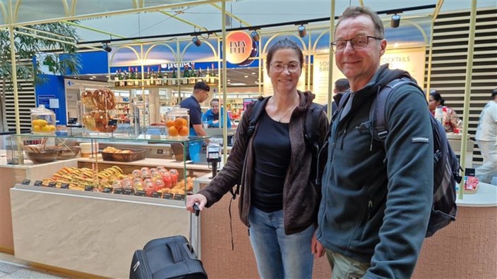 Reisende vor einem Gastro-Geschäft im Flughafen