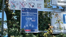 ein blaues Schild mit einem Warnhinweis das in der Zone vom Schild Radarüberwachung stattfindet.