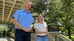 Angestellte vom Ordnungsamt stehen vor einem Gebäude und stellen die Radarüberwachung vor.