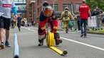 Ein Feuerwehrmann rollt in Uniform einen gelben Schlauch auf