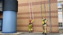 Zwei Feuerwehrmänner stellen Leitern auf