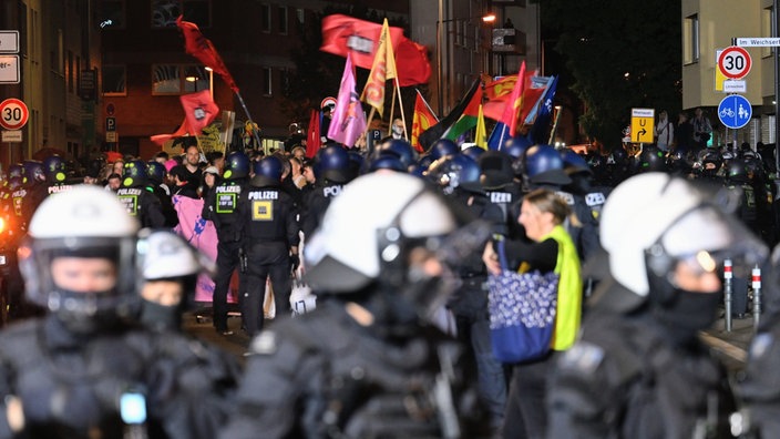 Teilnehmer (hinten) werden bei einem "Anti-Kriegs-Marsch" der Initiative "Rheinmetall Entwaffnen" durch die Polizei eingekesselt