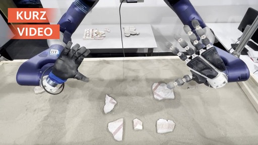 Roboterhände puzzeln Scherben zusammen.
