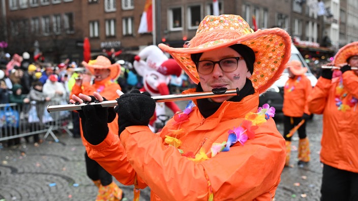 Ein Mann spielt Flöte auf dem Rosenmontagszug 