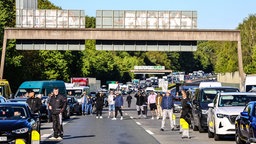 Auf der A45 stehen dutzende Autos im Stau. Die Menschen verlassen ihre Autos und stehen auf der Autobahn. 