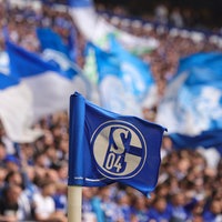 Eine Flagge des FC Schalke 04 vor den Fans im Stadion