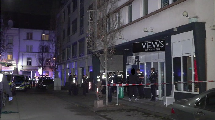Einige Polizisten stehen vor der Bar