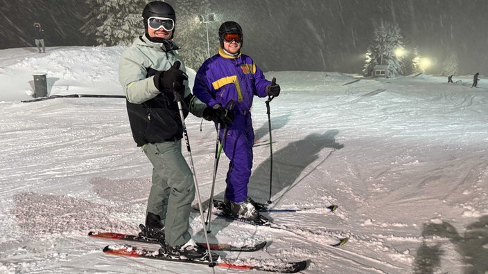 Zwei Skifahrer auf den weißen Pisten im Skigebiet Postwiese beim Flutlicht Skrifahren 