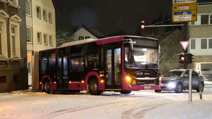 Ein Bus des Schienenersatzverkehrs steckt in Wuppertal auf einer verschneiten Straße fest.