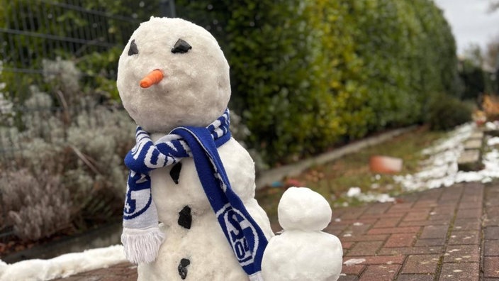 Ein Schneemann hat einen Schalke-Schal umgebunden