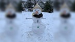 Der Schneemann Hubert mit bunten Knöpfen, einem Schal und einem Sommerhut