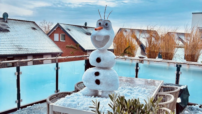 Der Schneemann "Olaf" steht auf einem Balkontisch