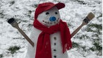 Ein Schneemann mit roter Cap, Schal und Armen aus Pinseln
